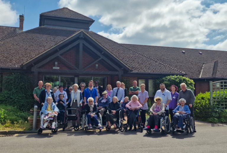 Group of residents and staff outside the facility