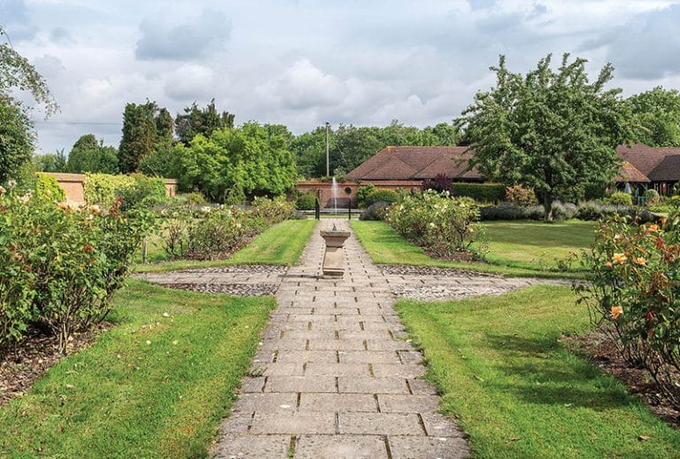 Beautiful garden pathway with greenery and fountain