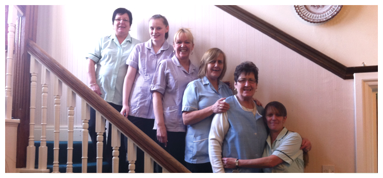 Staff members posing together on a staircase