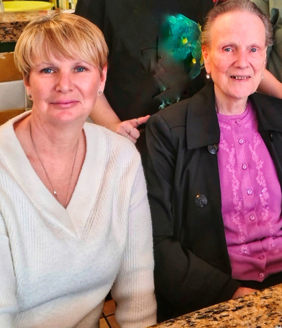 Two women smiling together in a facility.