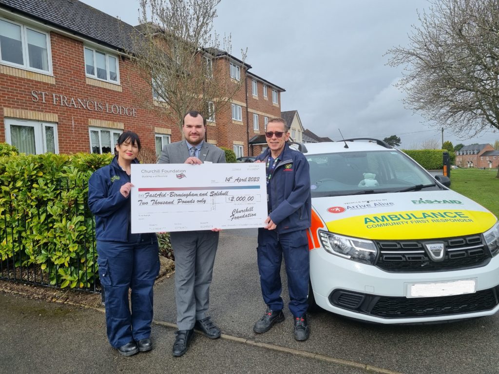 Staff presenting a check outside the facility
