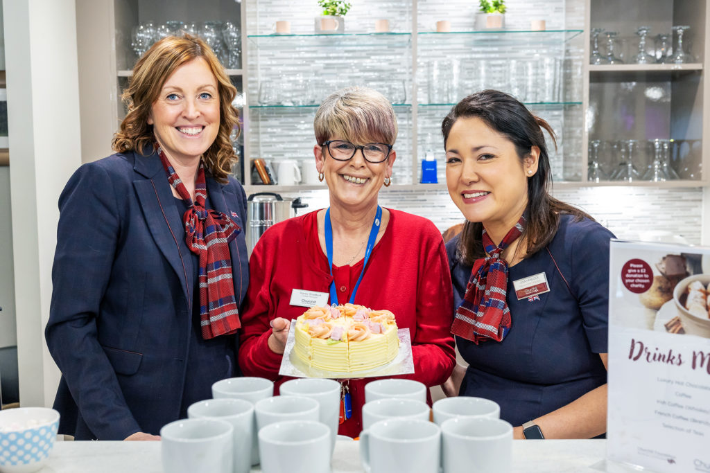 Three staff members celebrating with a cake.