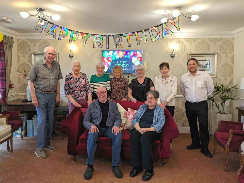 Residents and staff celebrating a birthday in a common area.