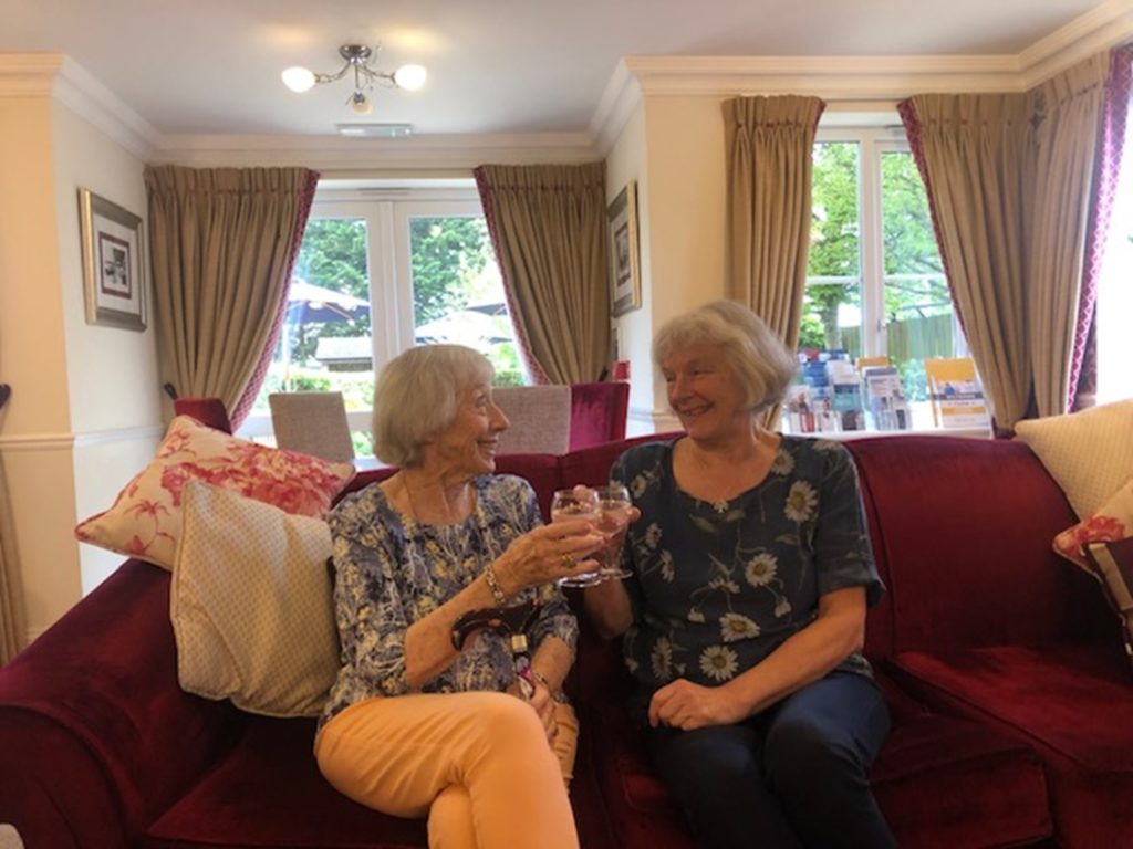 Two senior women enjoying a cheerful moment indoors.