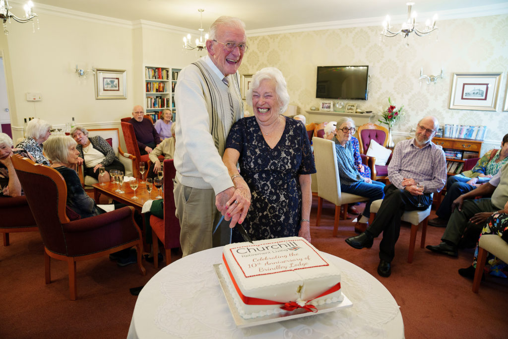 Residents celebrating with a cake in a common area.