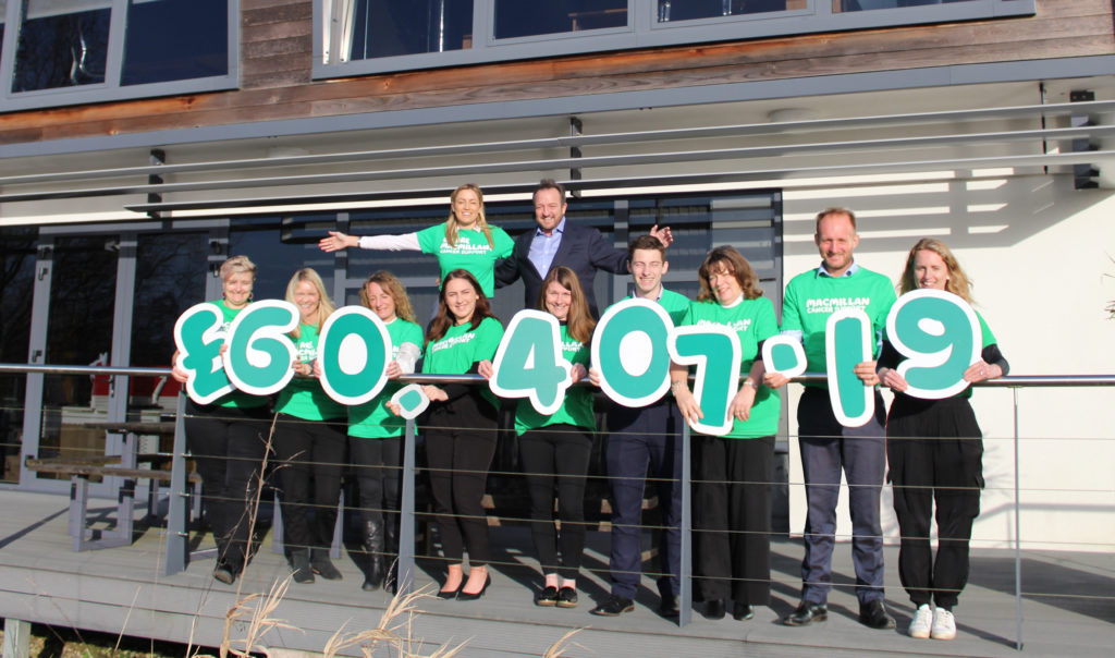 Group of people celebrating a fundraising achievement outside