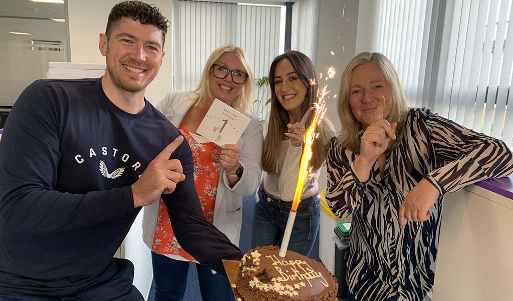 Staff celebrating a birthday with a cake.