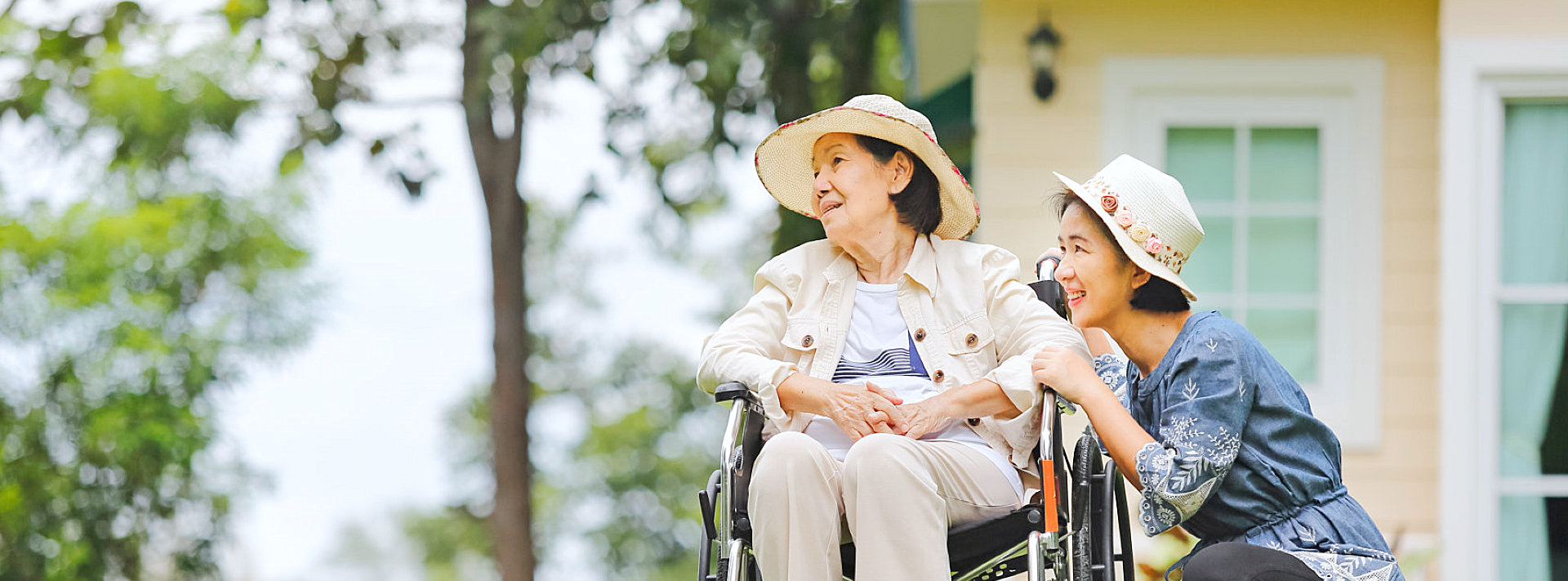 Senior woman in wheelchair with young companion outdoors
