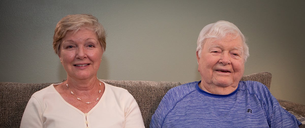 Two residents posing on a couch in a common area