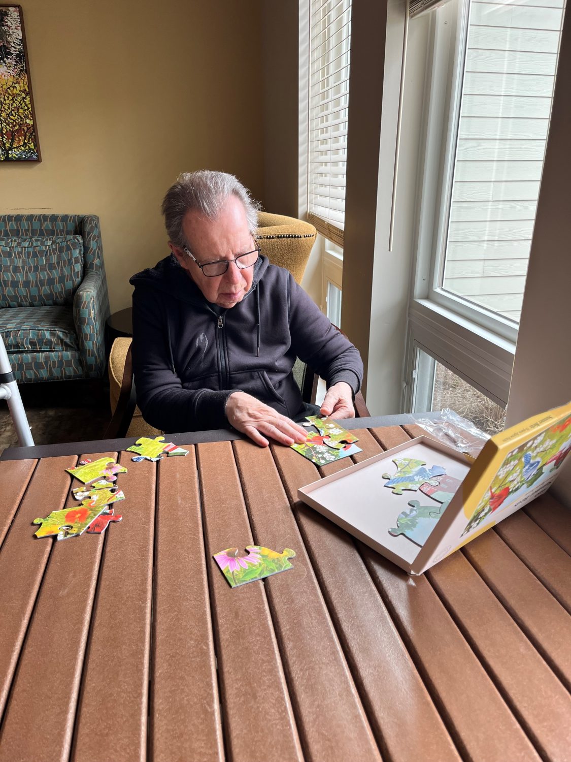 Resident assembling a puzzle in a cozy interior space