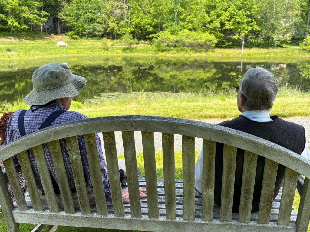 Two residents enjoying a peaceful view by the pond
