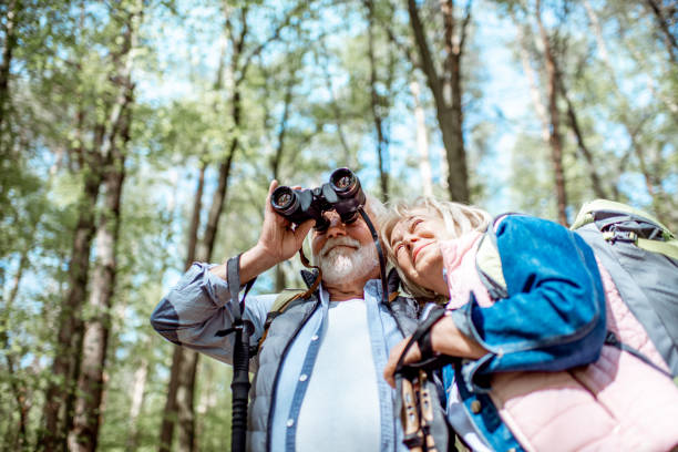 Two seniors enjoying nature with binoculars
