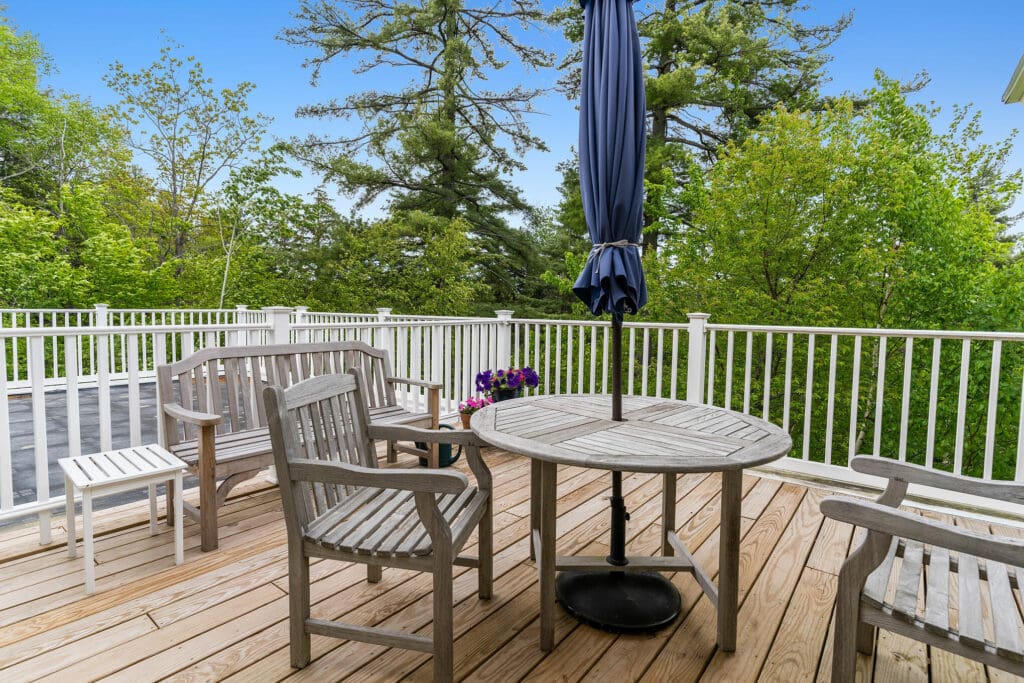 Outdoor seating area with wooden furniture and greenery