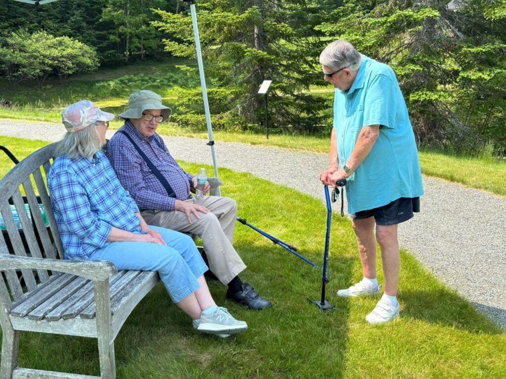 Residents enjoying a sunny day outdoors on a bench