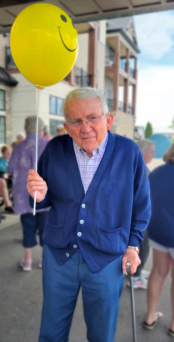 Resident holding a balloon at an outdoor event