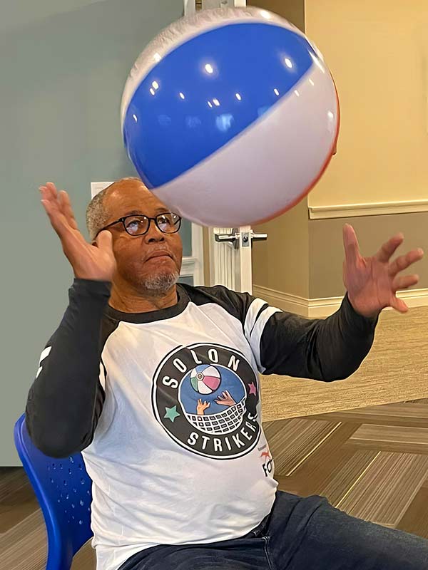 Resident playing with a beach ball indoors