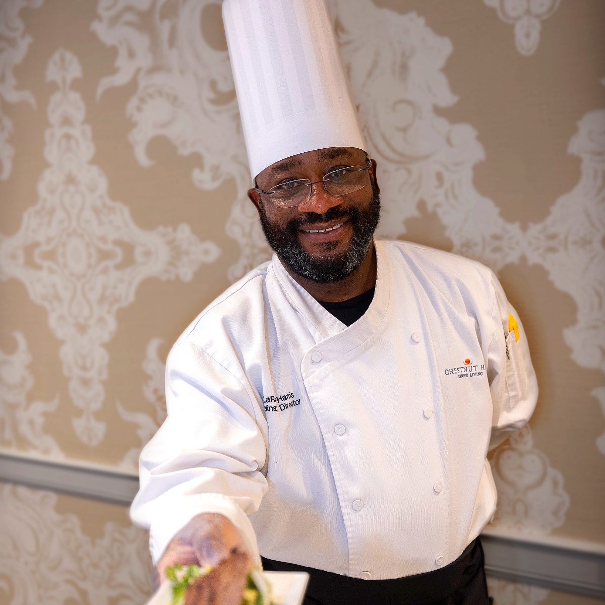 Chef presenting a dish in a dining area