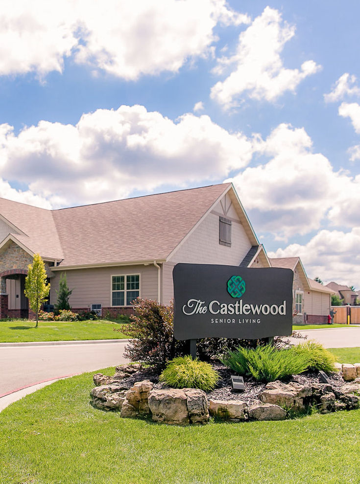 Exterior view of The Castlewood Senior Living sign and buildings