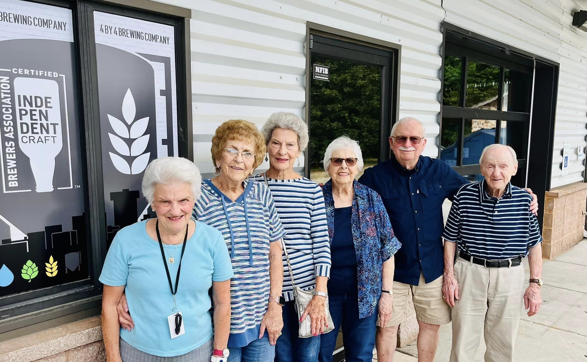 Residents smiling in front of a building