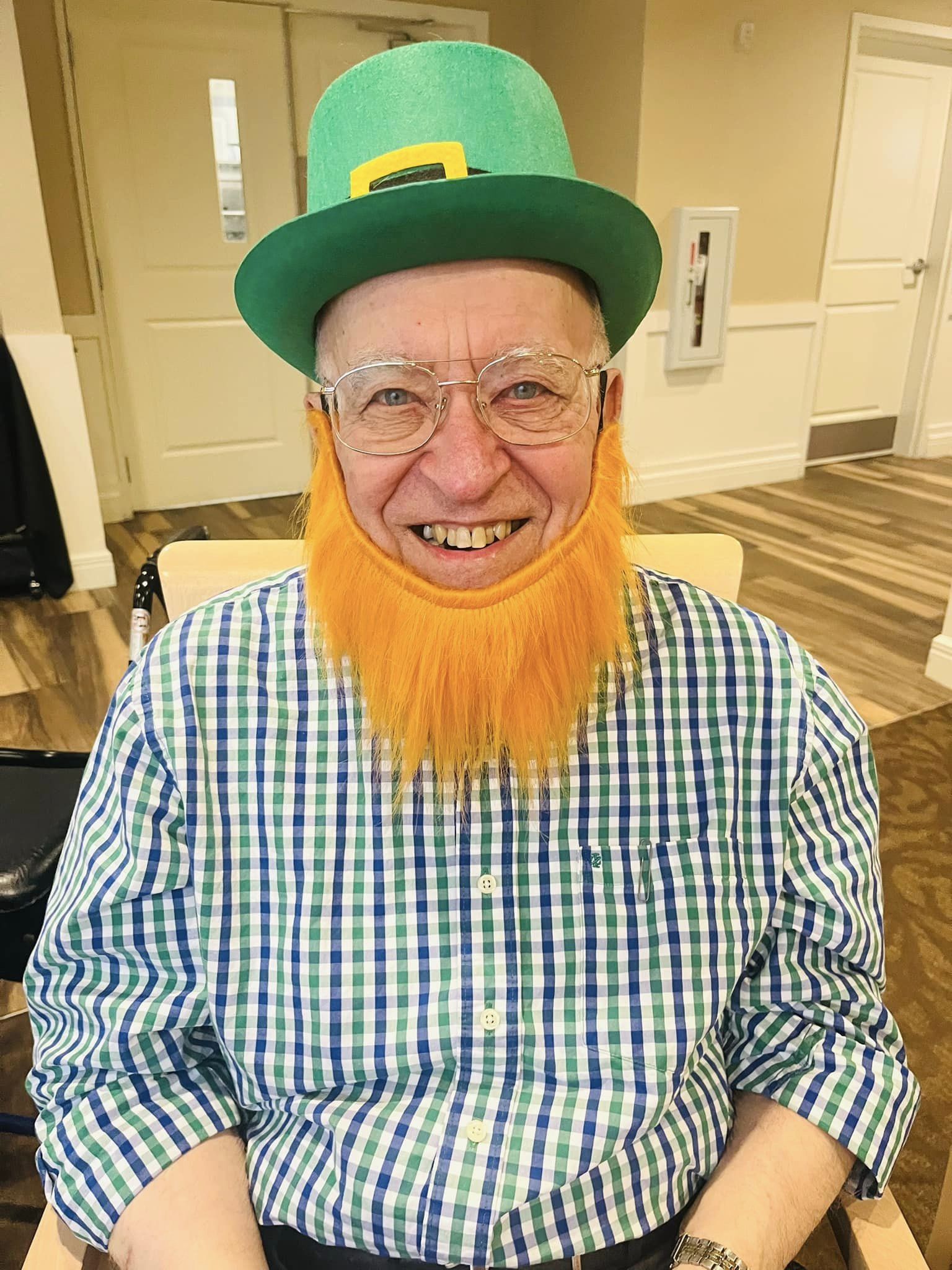 Resident dressed for a festive celebration with an orange beard and green hat.