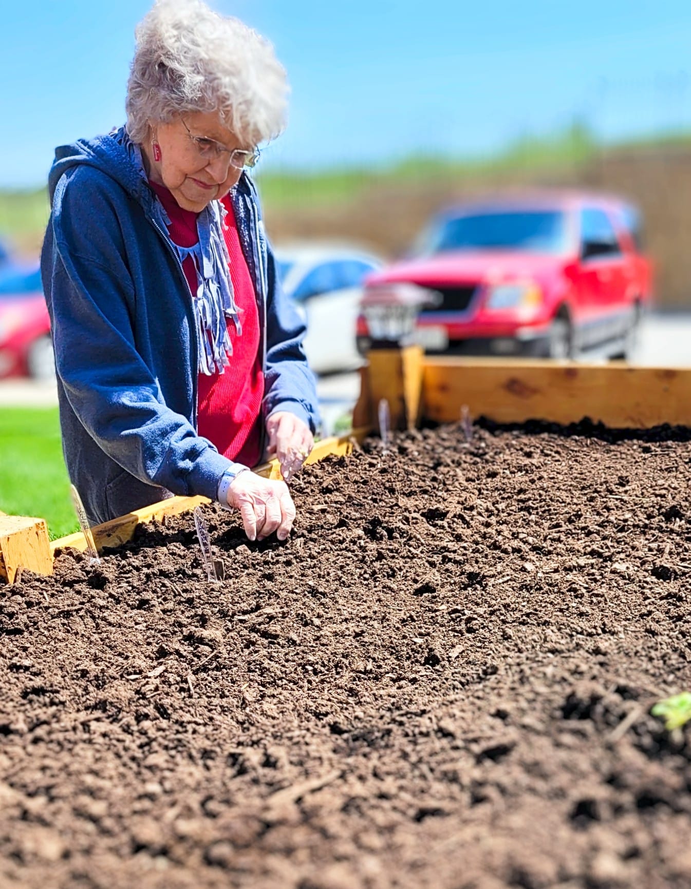 Resident gardening at a raised bed in outdoor space