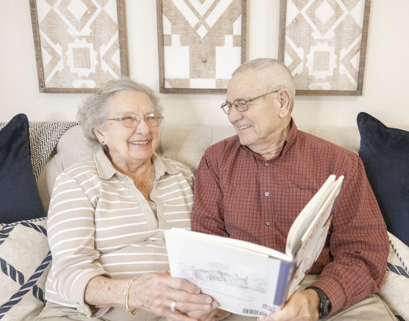 A smiling couple reading together in a cozy setting