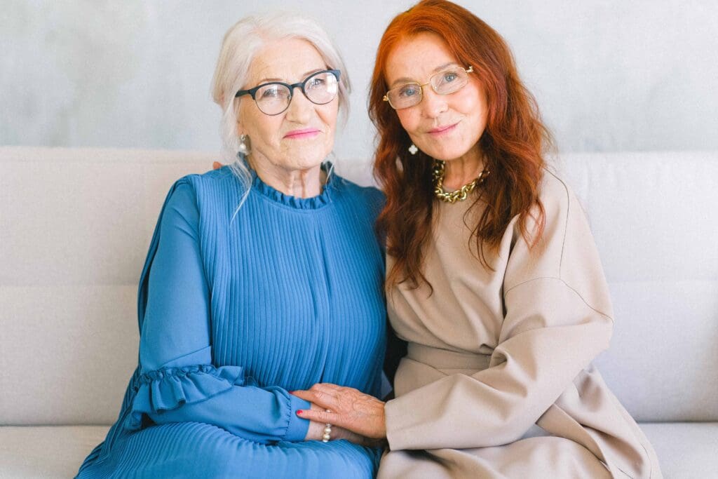 Two seniors smiling together on a couch