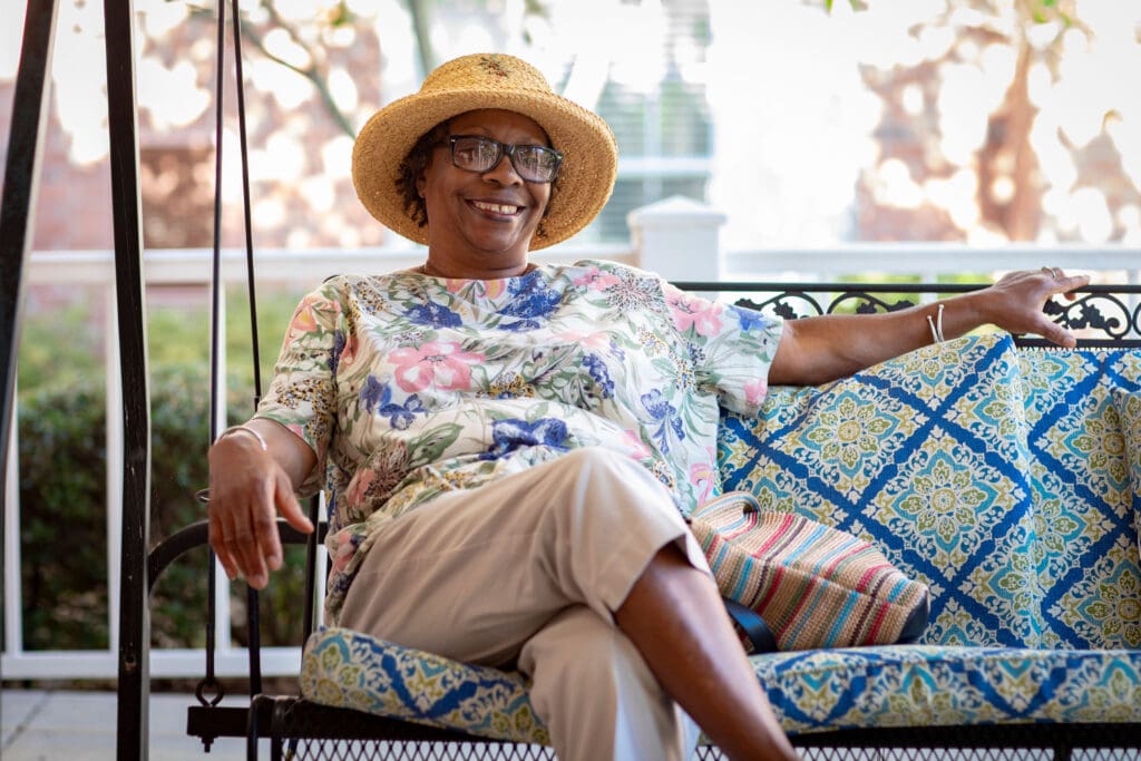 Resident enjoying outdoor seating with a smile