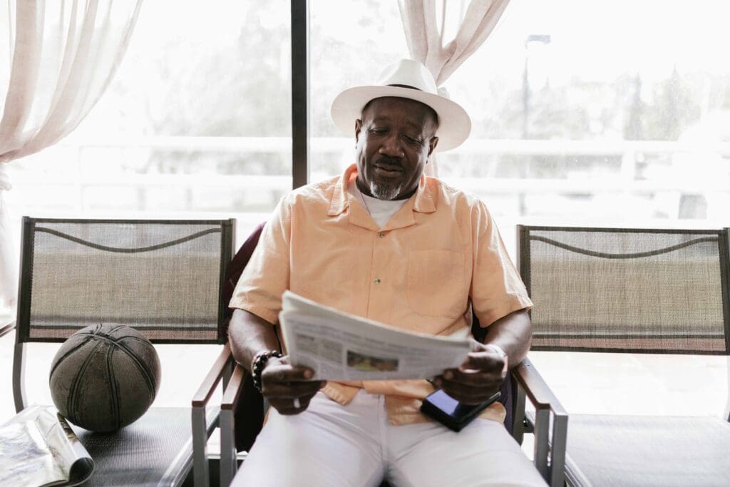 Resident reading a newspaper indoors with casual attire