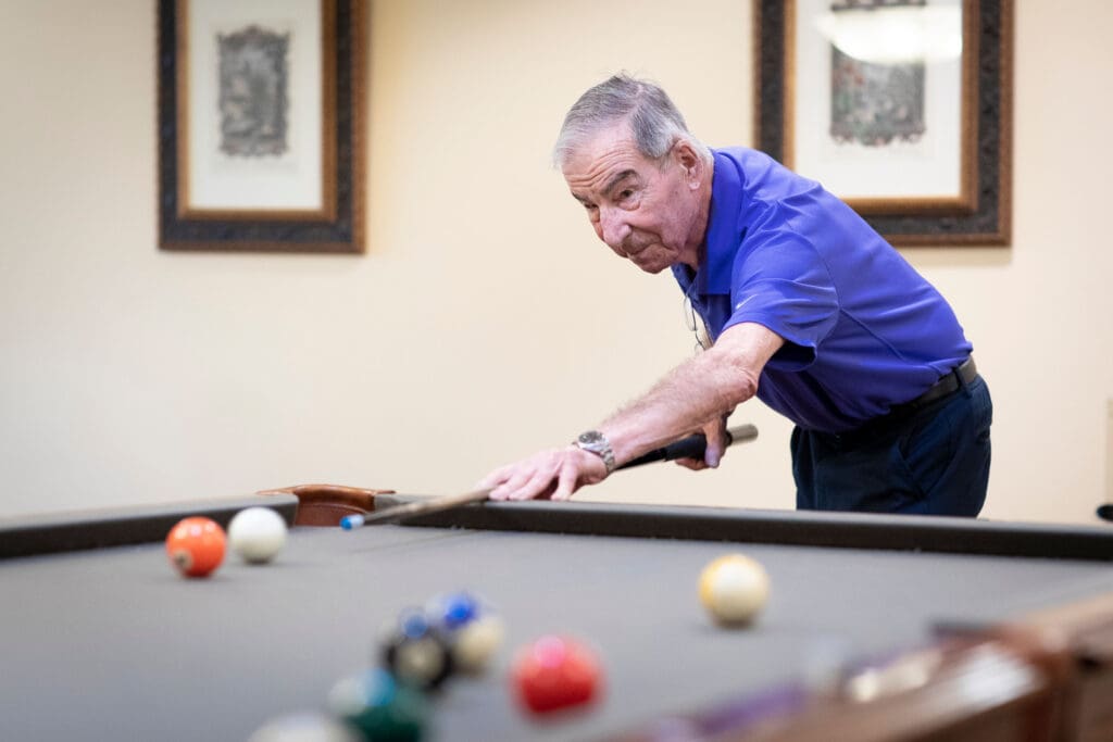 Resident playing billiards in a common area