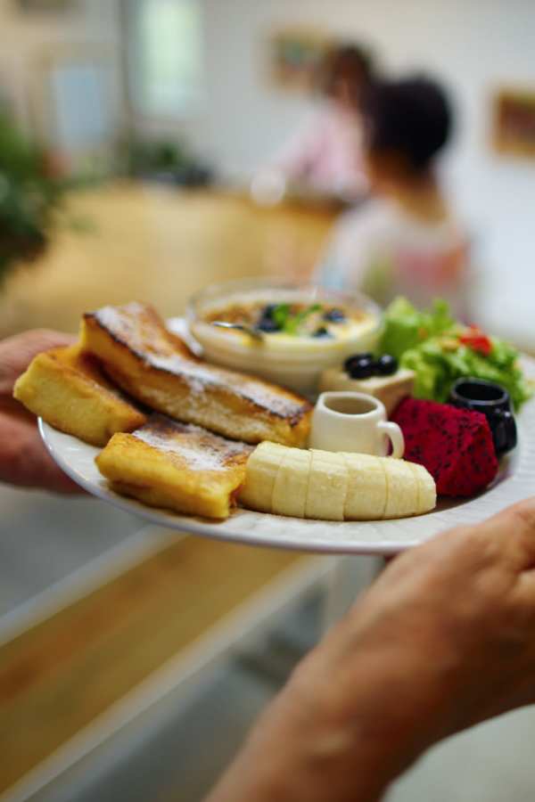 Plate of food being held, with residents in background