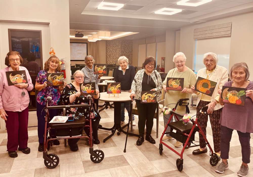 Residents holding their artwork in a common area