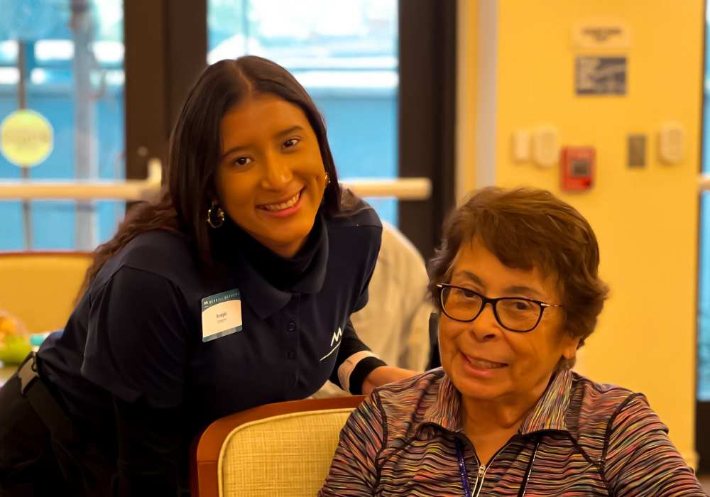A resident and staff member smiling in a common area