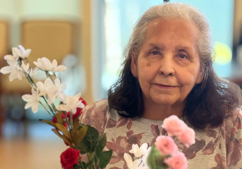 A resident holding artificial flowers in a common area