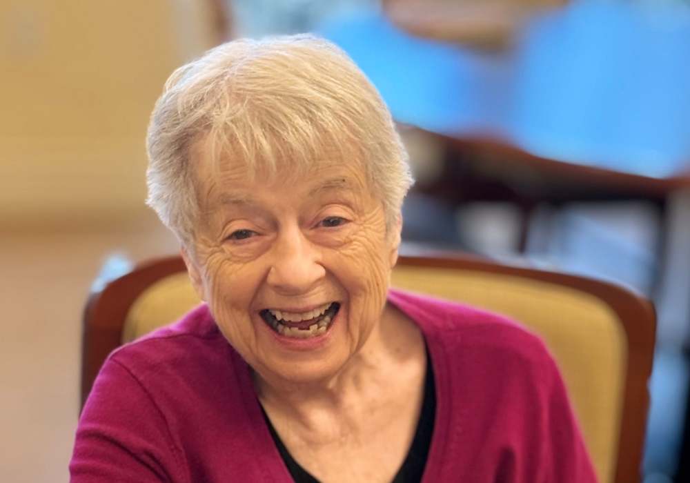 A smiling elderly woman enjoying herself in a common area