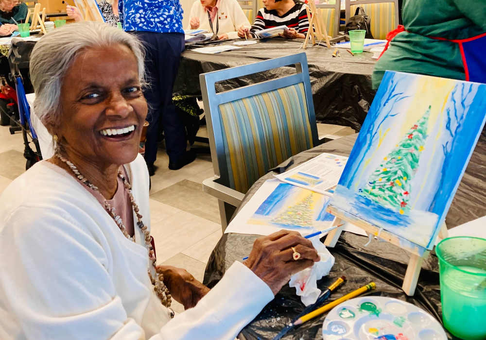 Resident painting a winter scene in an art activity