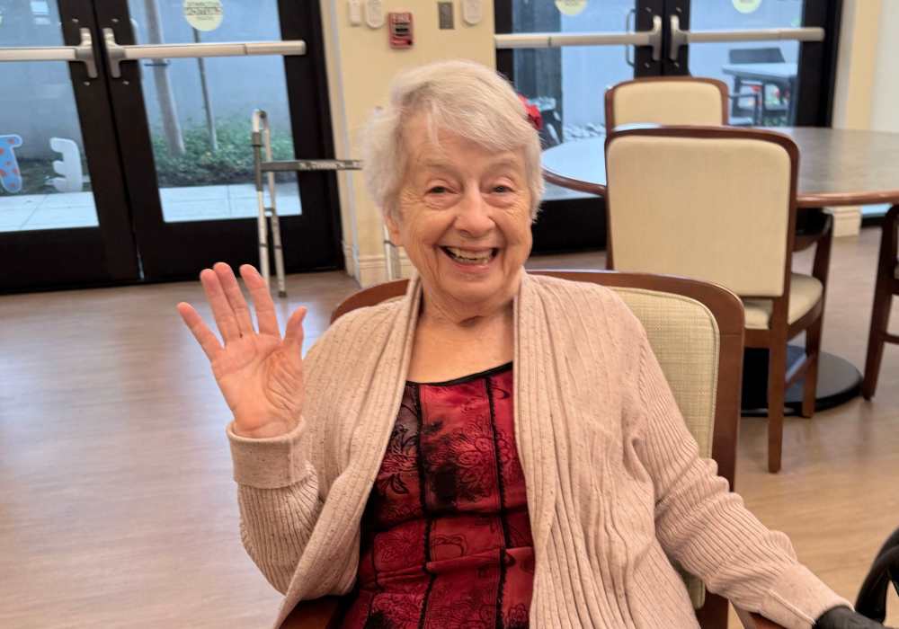A smiling resident waving in a common area