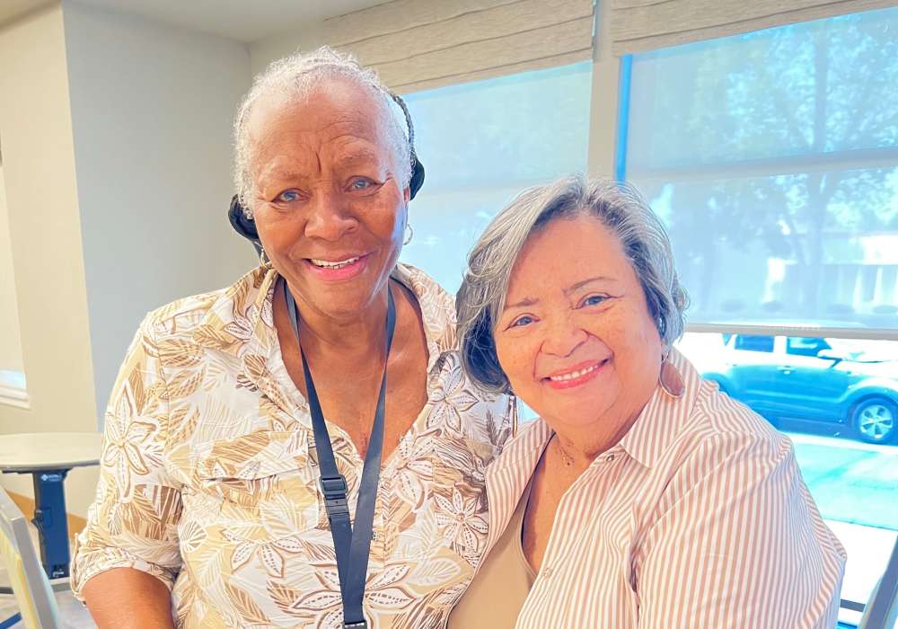 Two smiling residents posing together indoors
