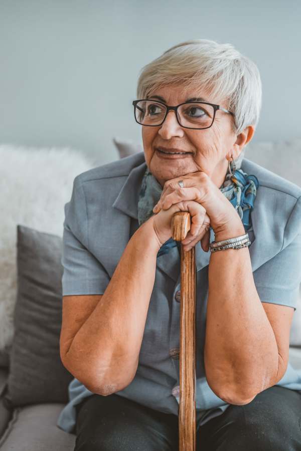 Senior woman smiling and resting on a cane