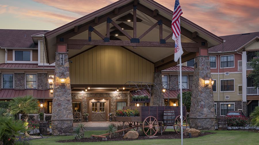 Entrance of American House Wildwood with landscaping and flags
