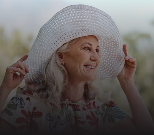 Senior woman smiling while wearing a large sun hat
