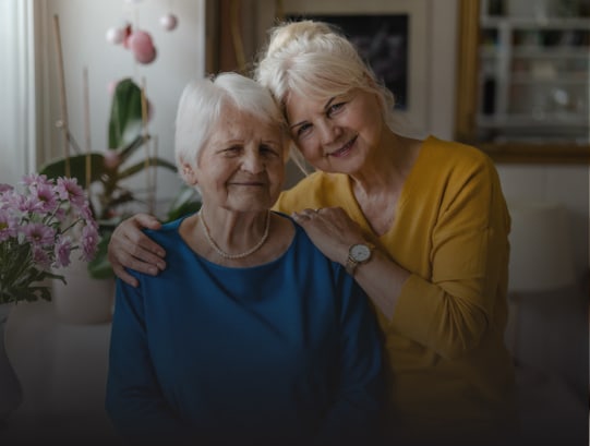 A resident and staff member smiling together