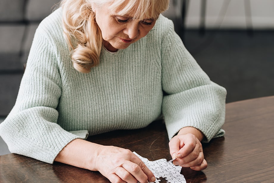 Senior woman focusing on a jigsaw puzzle in a common area