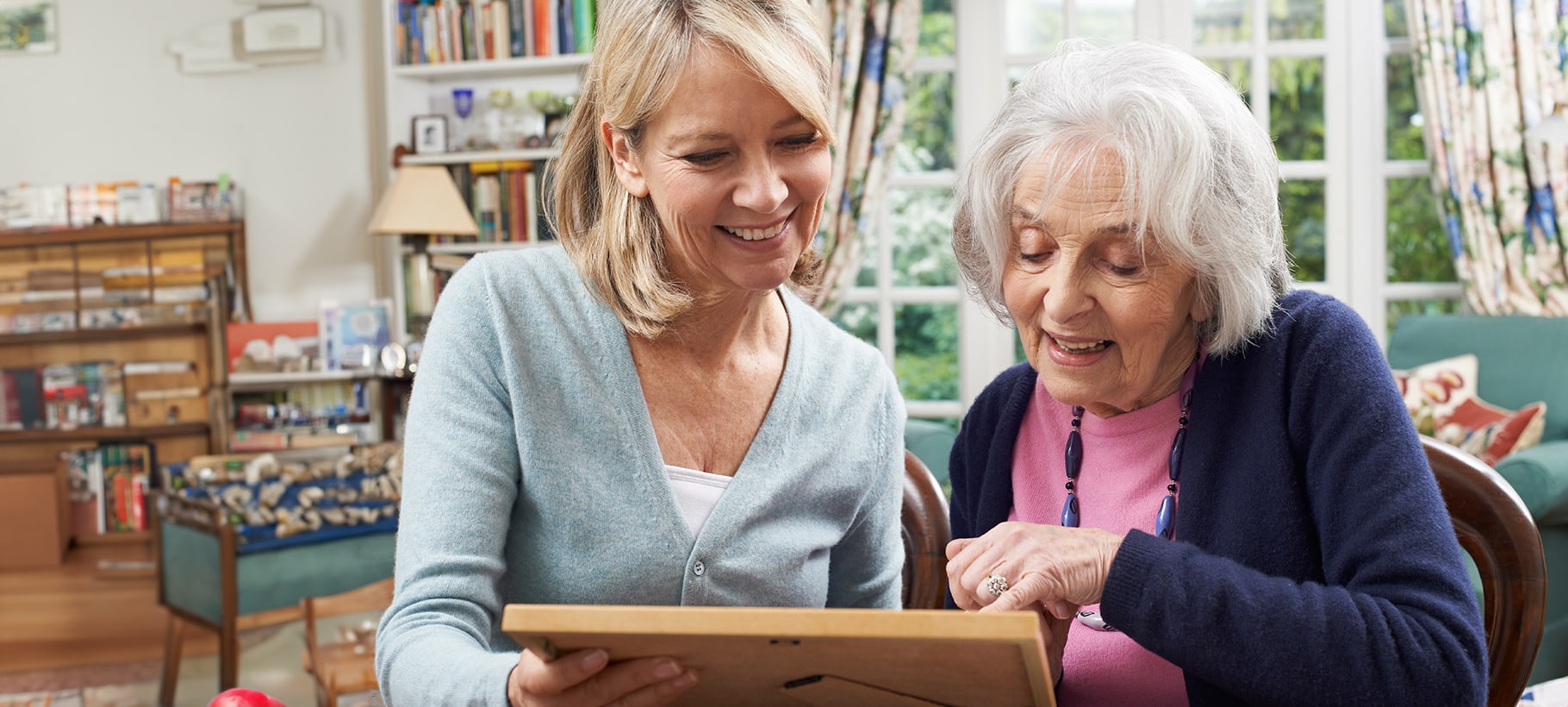 A staff member and resident looking at a photo together