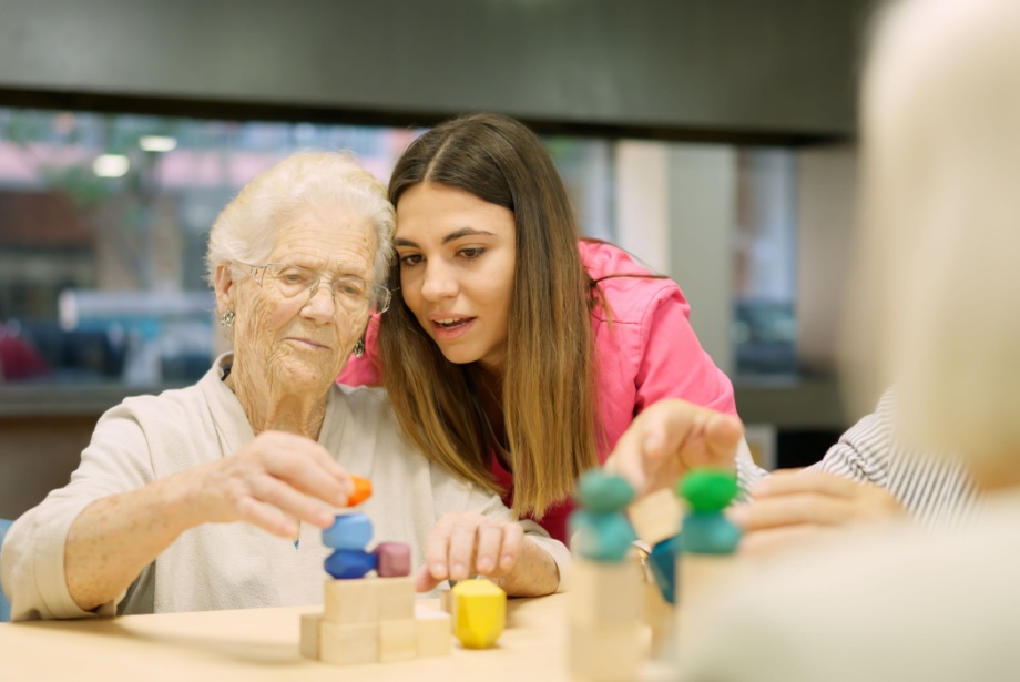A caregiver helping a resident with a stacking activity