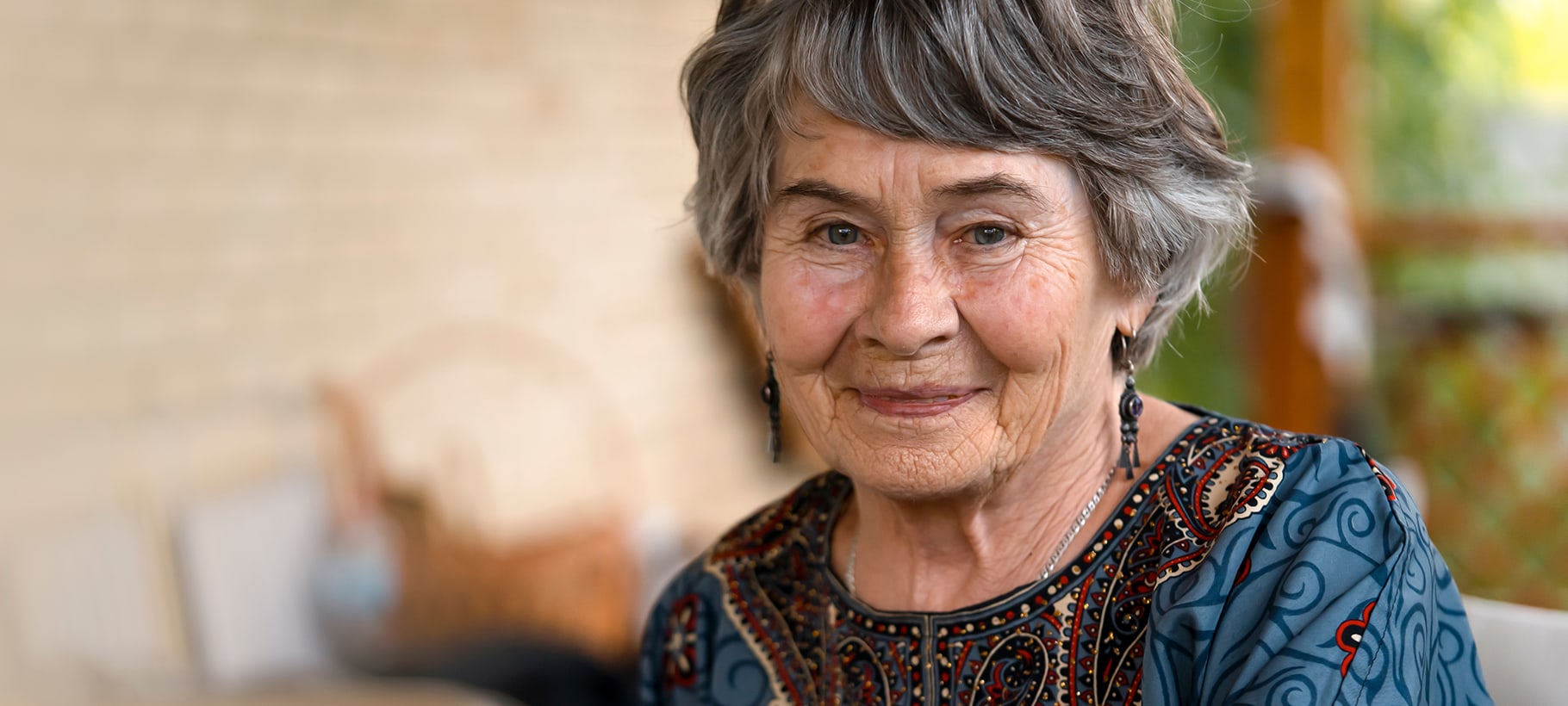 A smiling senior woman with gray hair outdoors