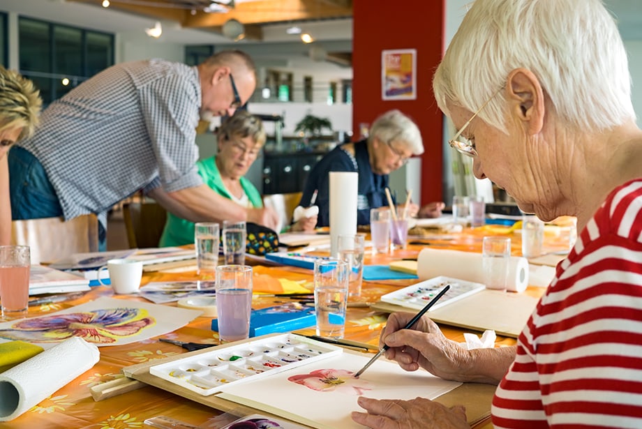 Residents engaged in a painting activity at a table