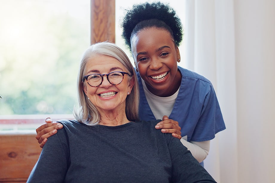 A caregiver smiling with a resident in a cozy interior setting
