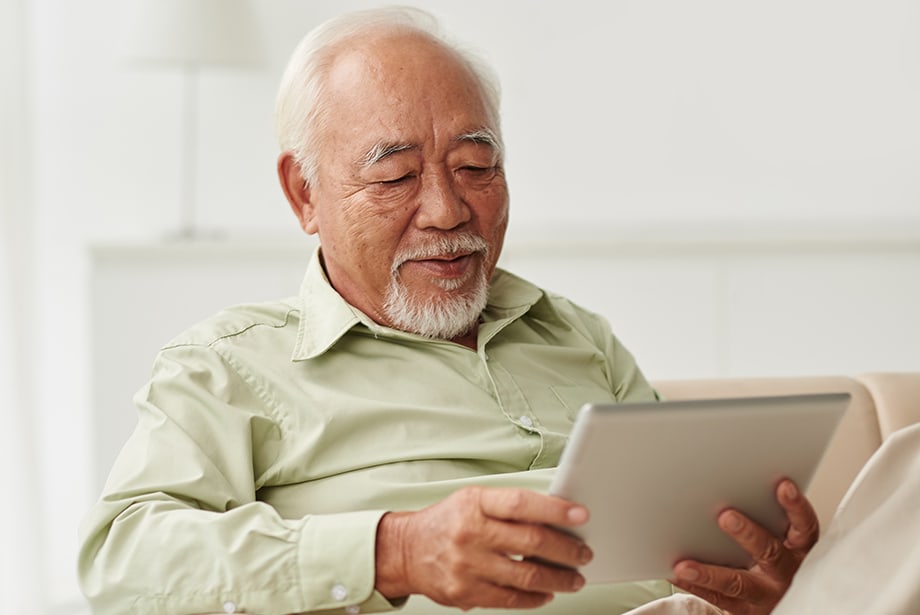 Senior man enjoying a tablet in a bright room