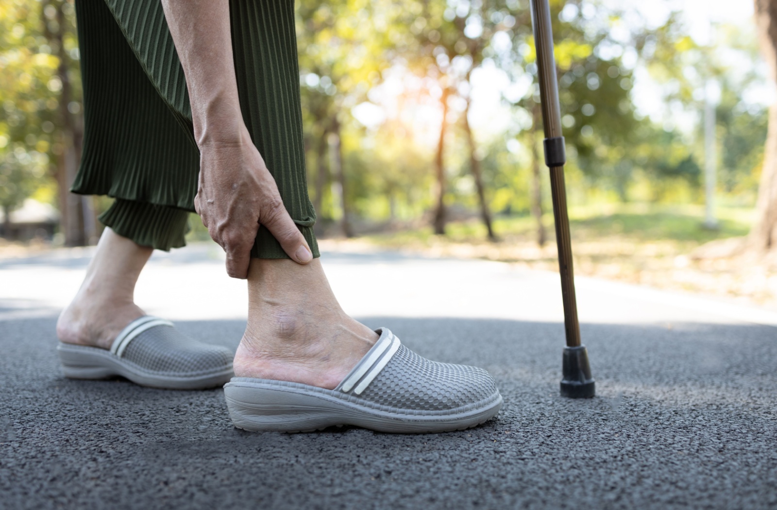 Senior using a cane while walking in a garden